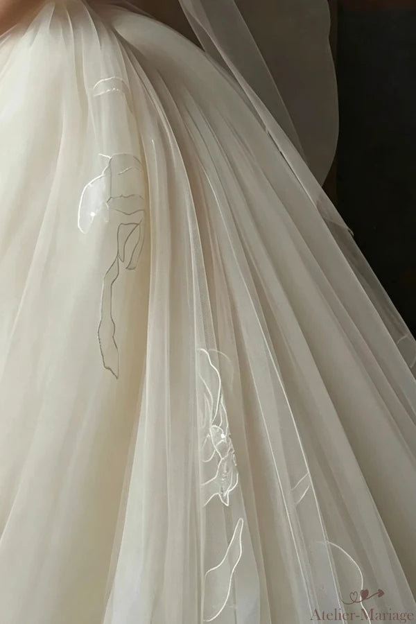 Détail de la dentelle appliquée sur le haut de la jupe en tulle, montrant la transition harmonieuse et la richesse des motifs floraux.