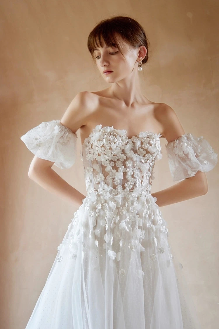 Mariée portant une robe avec manches bouffantes amovibles en tulle et fleurs.
