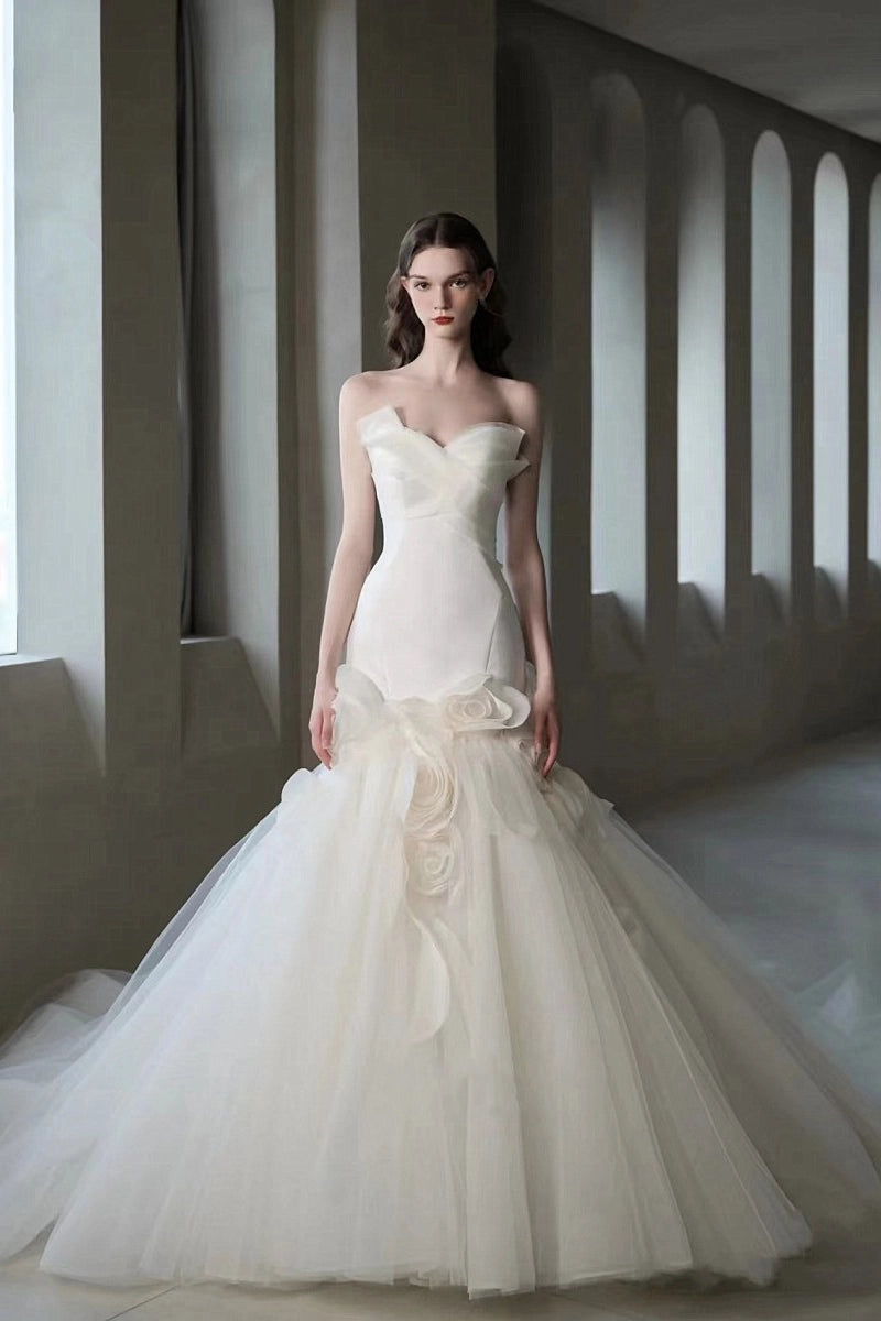 Robe de mariée coupe sirène avec corsage en satin lisse et jupe évasée en tulle volumineux.