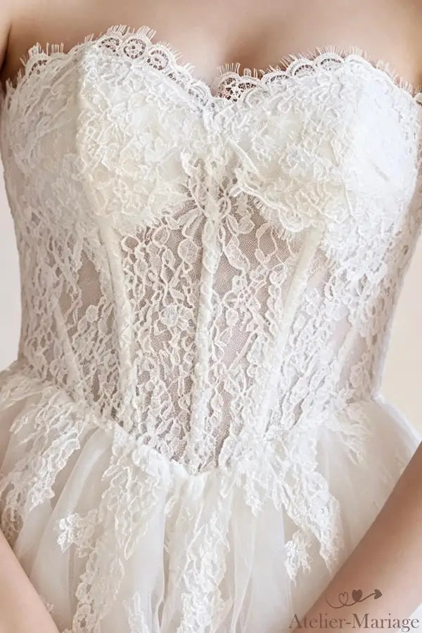 Gros plan sur mariée portant la robe de mariée bohème en dentelle cousu main, bustier coeur raffiné.