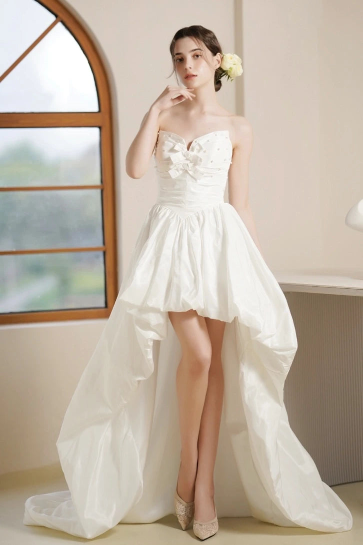 Élégance du bustier sans bretelles perlé mettant en valeur le port de tête de la mariée.