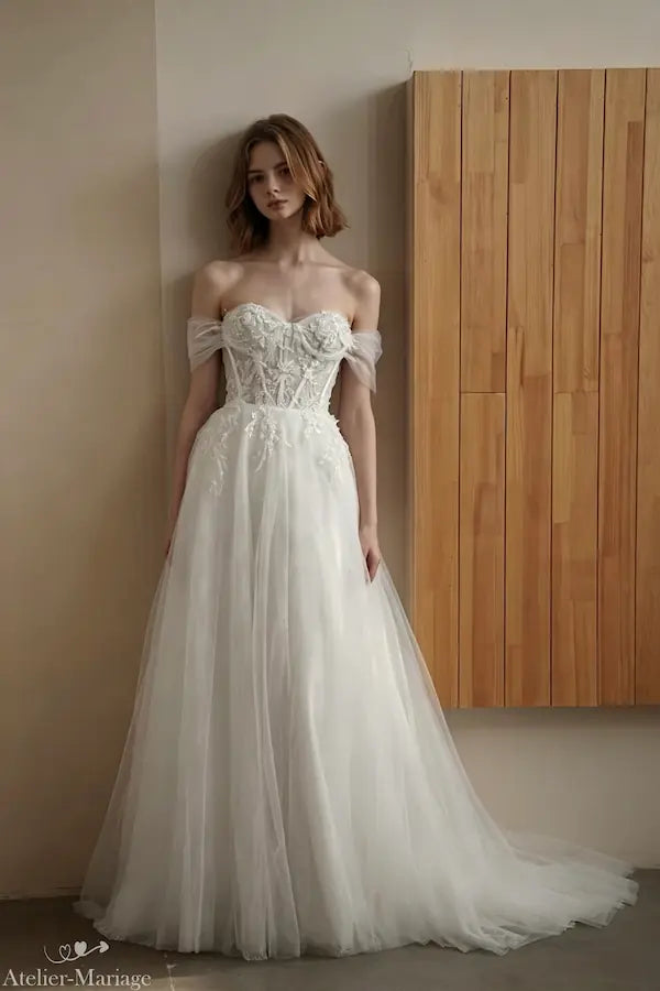 Robe de mariée transformable avec col bateau fleuri et jupe vaporeuse.