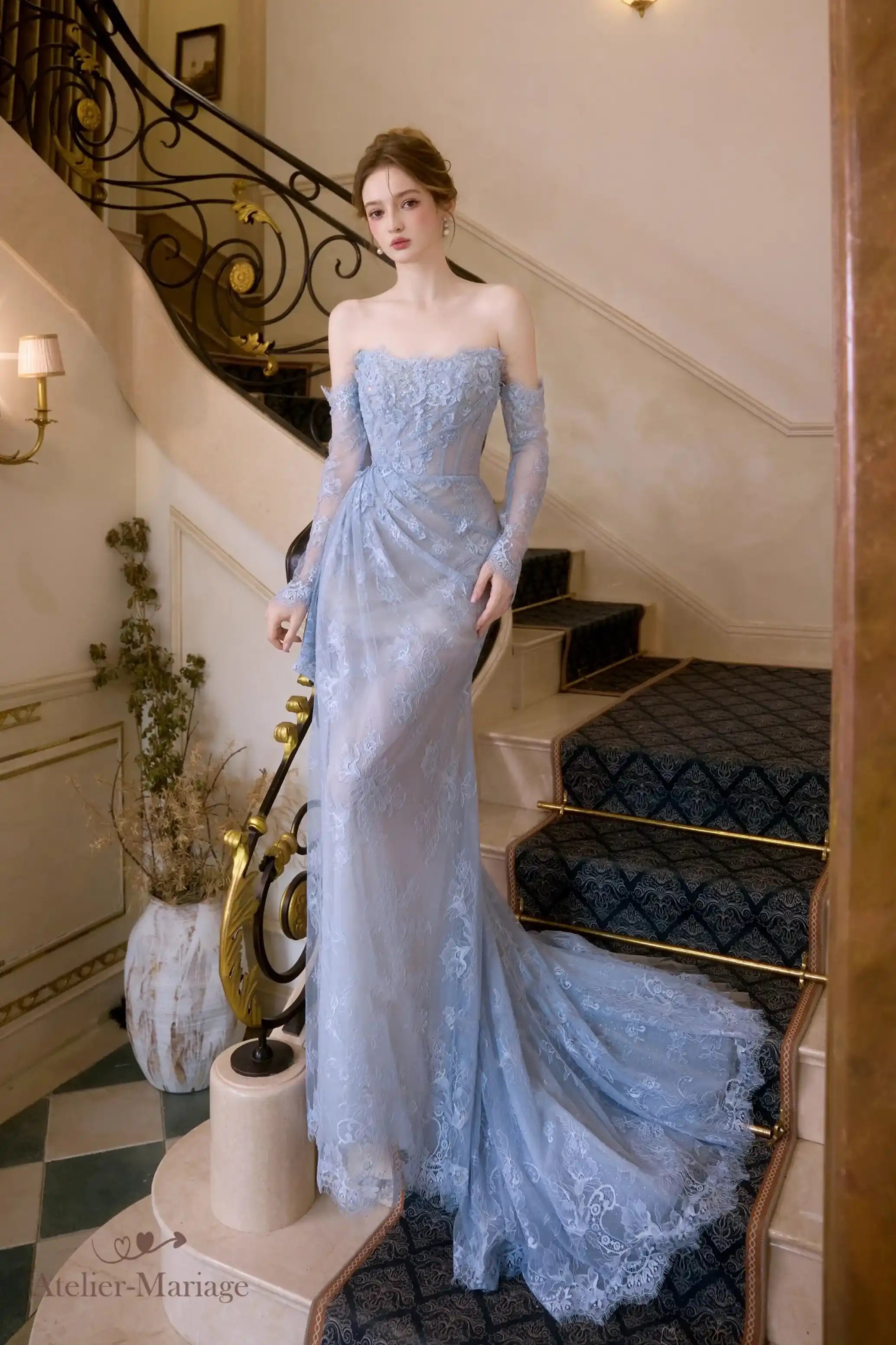 Mariée élégante portant une robe bleu glacier en dentelle avec une fente glamour sur la jambe.