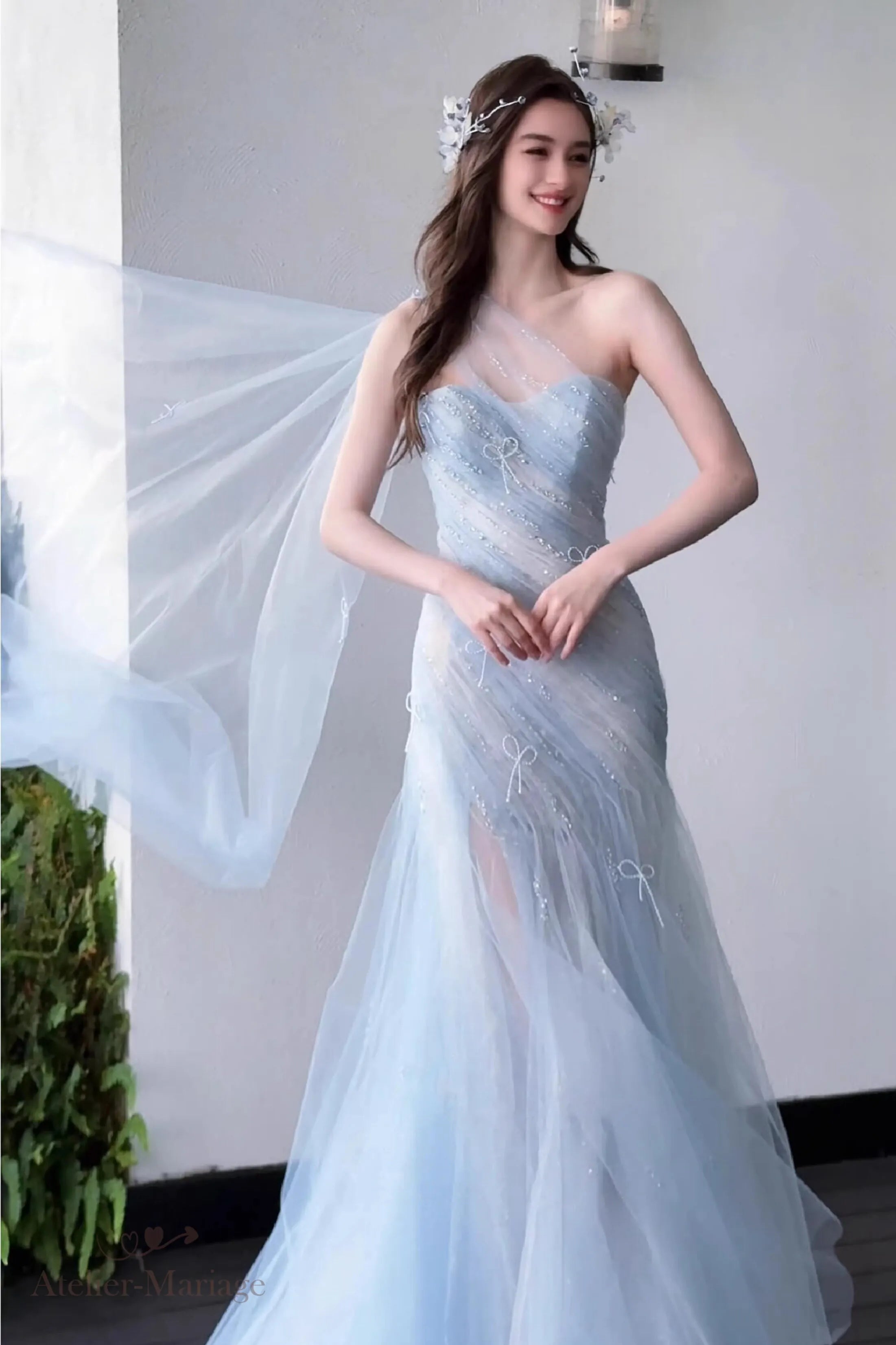 Vue de face mettant en valeur le tulle fluide et le corset de la robe de mariée bleu poussiéreux.