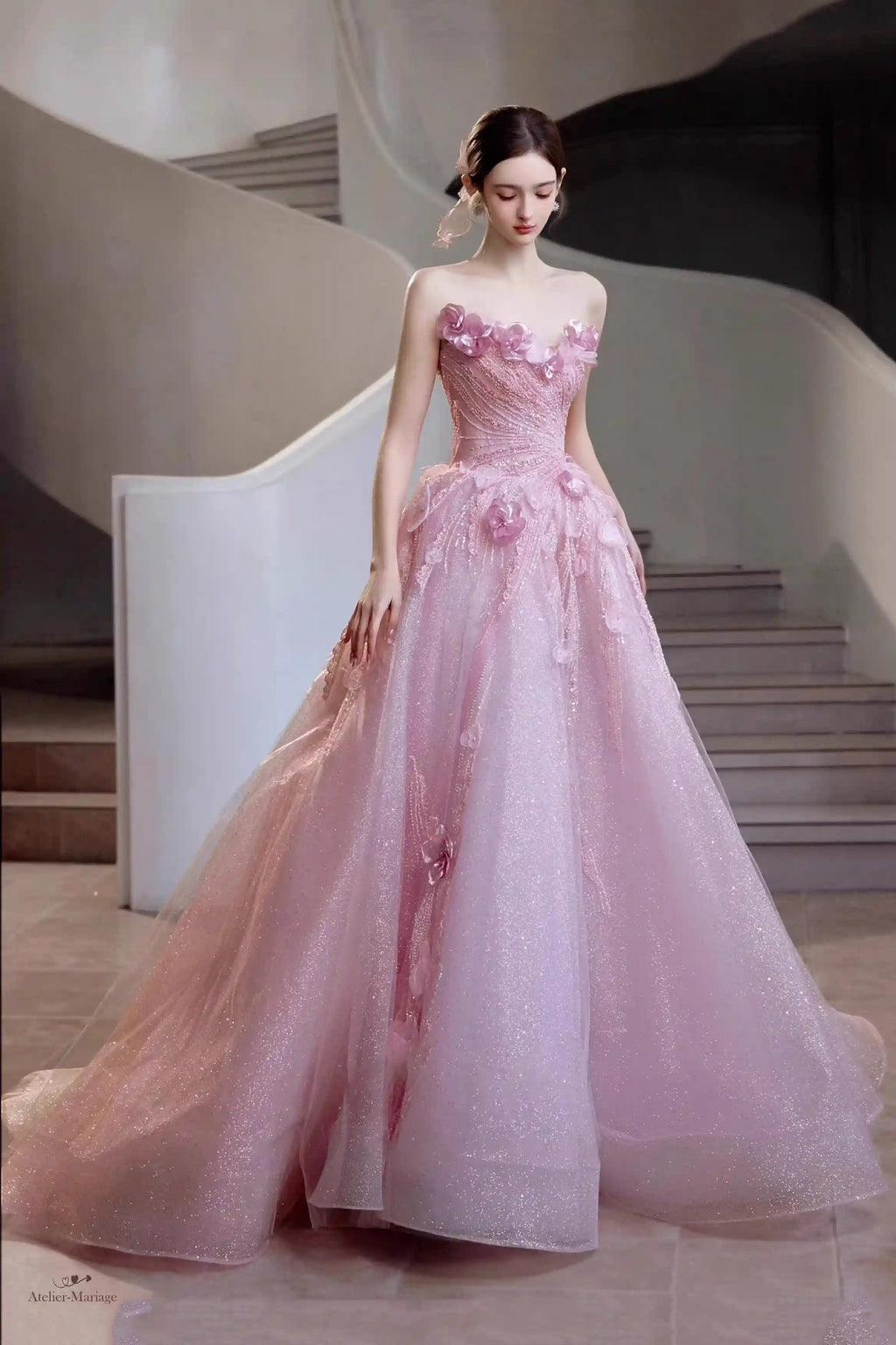 Mariée souriante portant une robe blush scintillante avec fleurs 3D et décolleté en cœur.