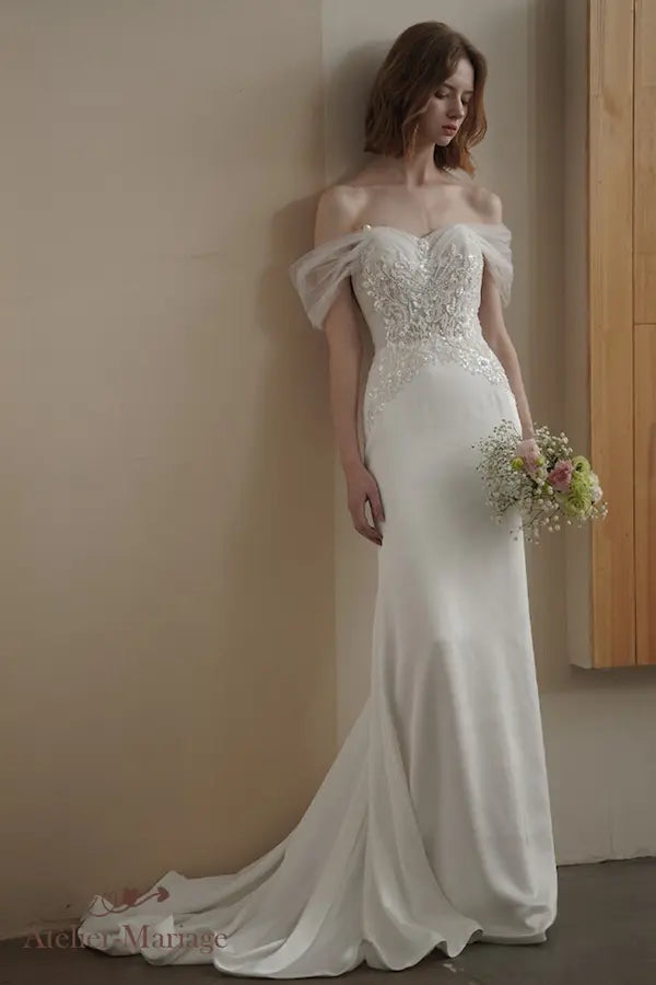 Robe de mariée bohème chic en satin et tulle ivoire, décolleté Bardot et jupe évasée.