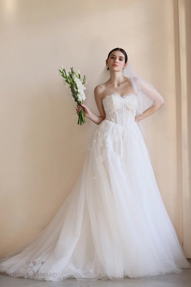 Mariée portant une robe bohème, tenant des fleurs