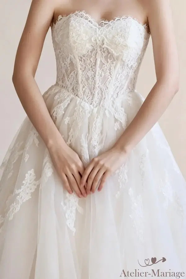 Détail de l'encolure et des fleurs 3D sur le bustier de la robe Atelier-Mariage
