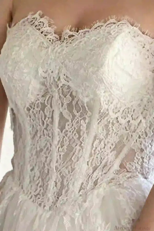 Gros plan sur le bustier en dentelle délicate artisanale et le sur-mesure haute couture, robe de mariée