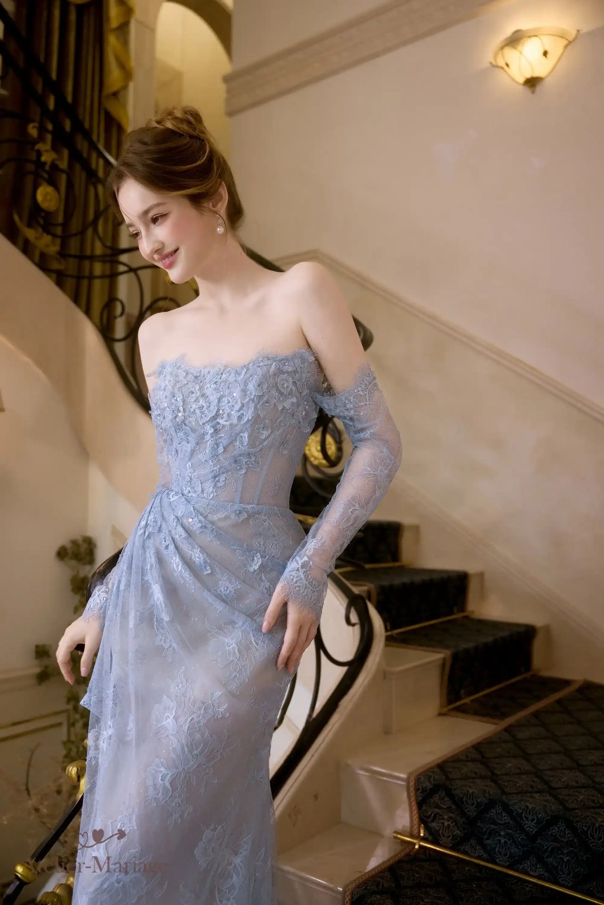 Robe de mariée romantique de couleur bleu poudré mettant en valeur la transparence de la dentelle.