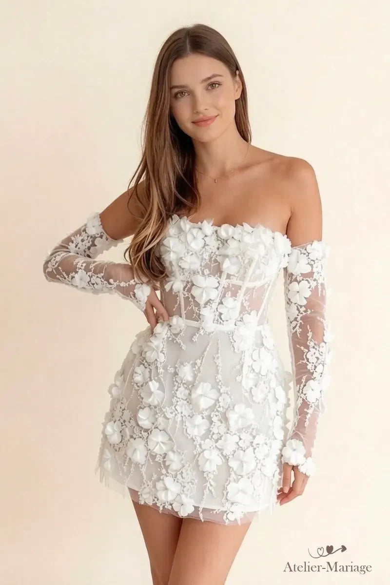 Mariée souriante en robe courte à fleurs 3D, vue de trois-quarts avec ses manches en dentelle