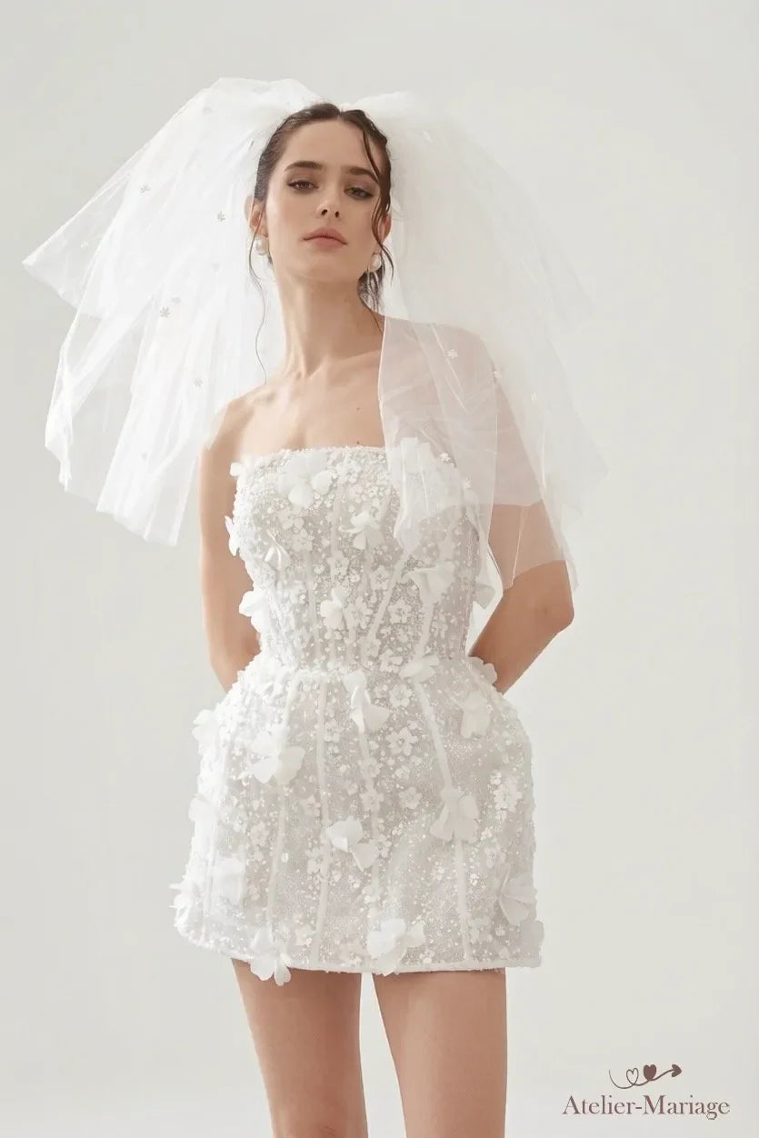 Mariée en robe courte perlée à bustier droit, associée à un voile court en tulle