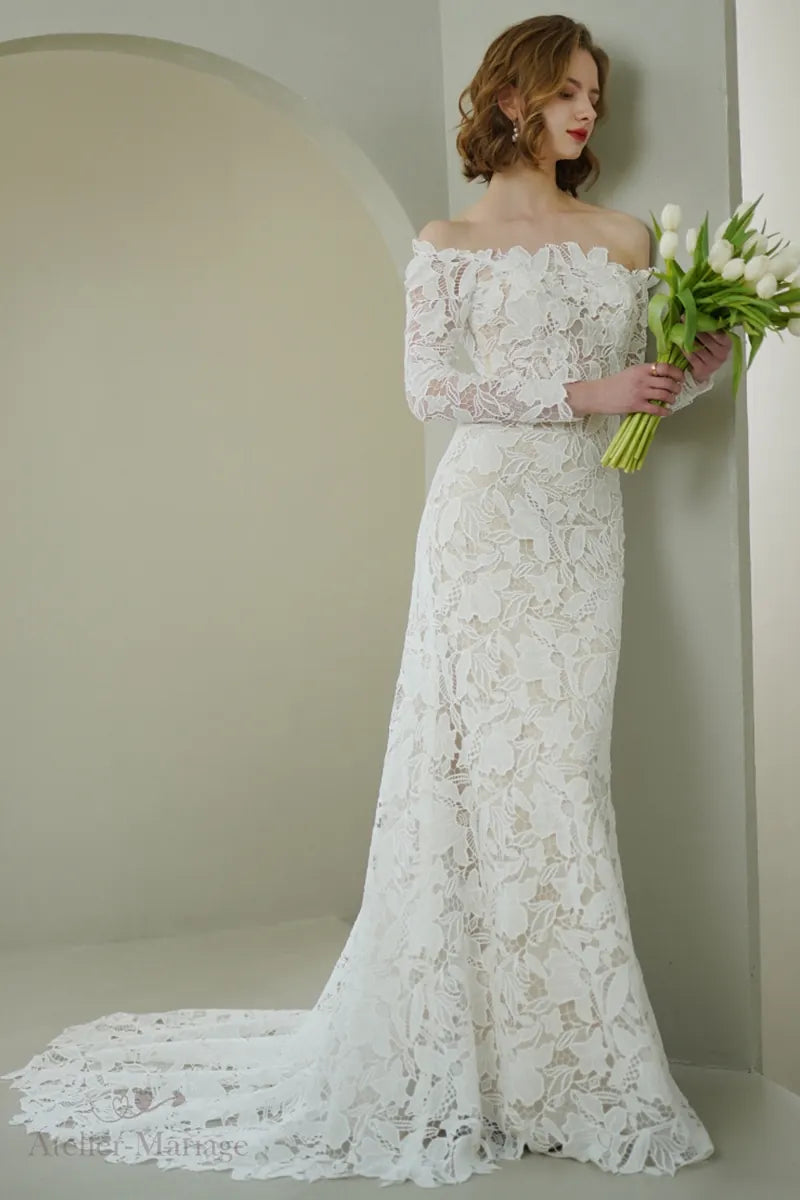 Mariée portant une robe en dentelle à manches longues col Bardot, sexy