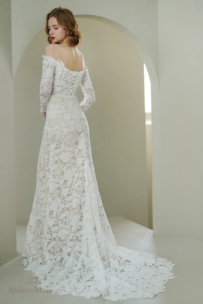 Jupe élégante de la mariée portant une robe en dentelle à manches longues col Bardot