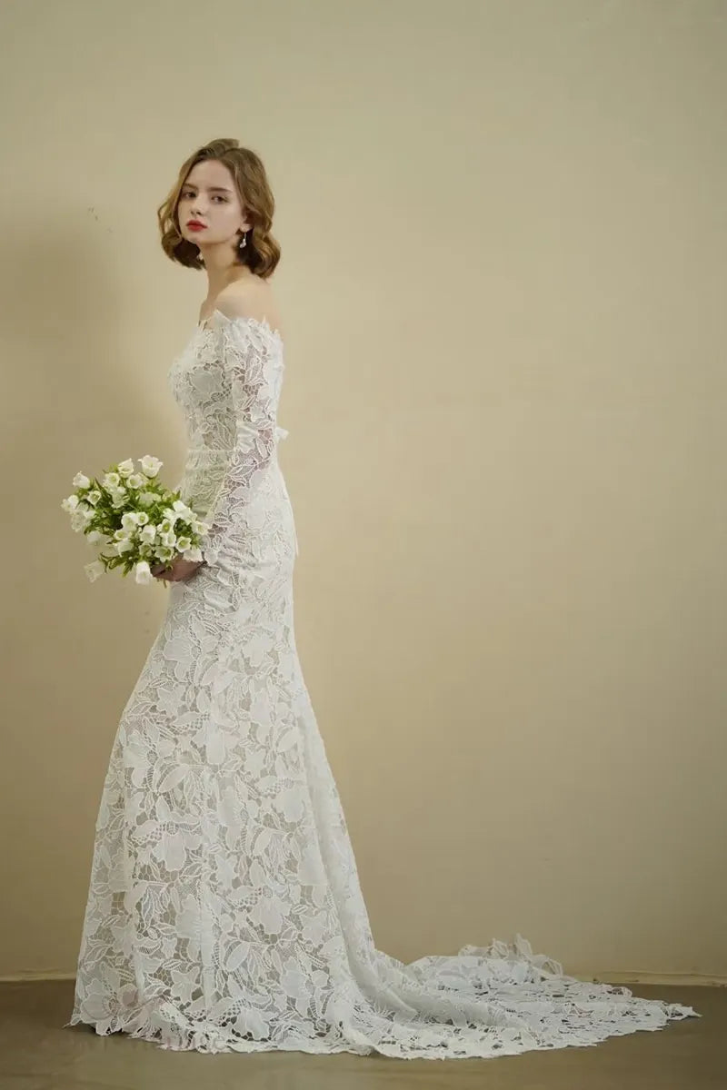 Jupe élégante de la mariée portant une robe en dentelle à manches longues col Bardot