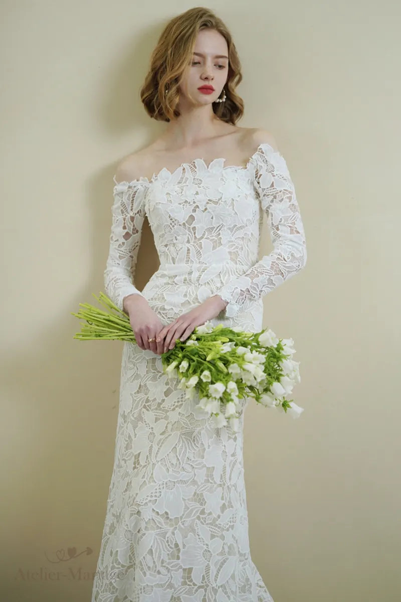 Mariée portant une robe en dentelle à manches longues col Bardot avec allure divine