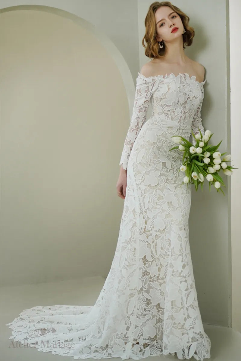 Mariée portant une robe en dentelle à manches longues col Bardot, allure haut de gamme