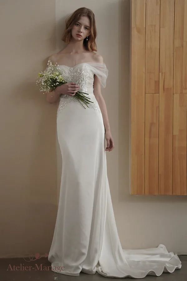 Robe de mariée coupe fourreau avec perlage intégral et finitions artisanales traditionnelles.