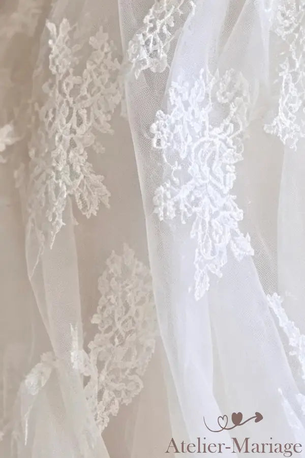 Détail des fleurs 3D et du tulle plissé sur la jupe, robe Atelier-Mariage