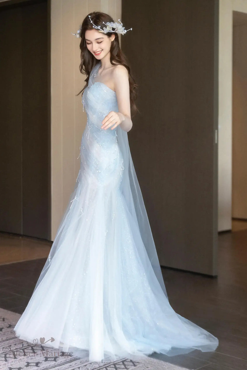 Une mariée radieuse dans sa robe de mariée originale couleur bleu ciel brumeux.