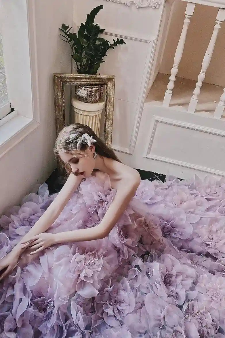 Pose romantique de la mariée au sol, soulignant l'originalité et le volume féerique de la robe lilas.