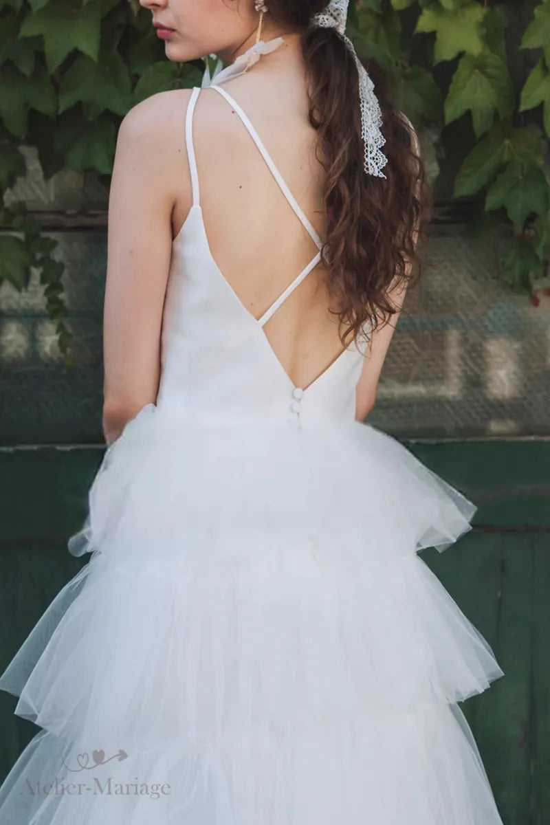 Détail arrière de robe de mariée princesse en satin et tulle multicouches