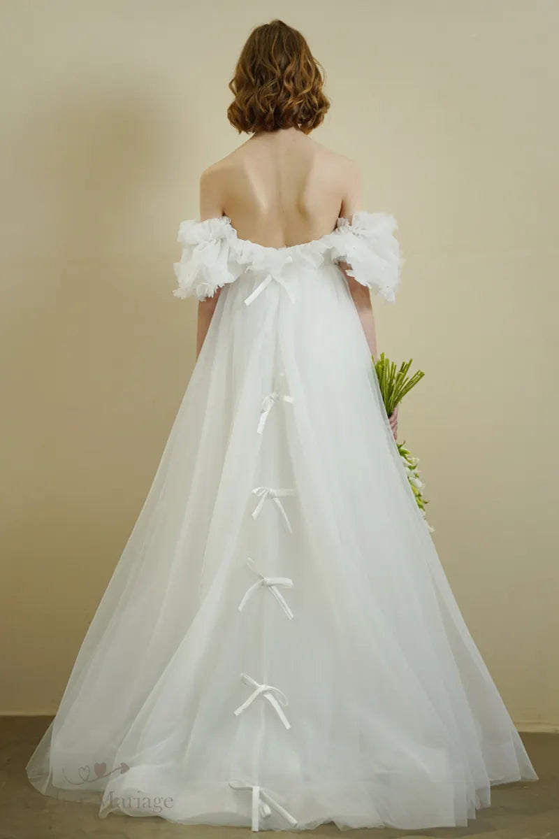 Dos de la mariée portant une robe romantique bohème à manches bouffantes