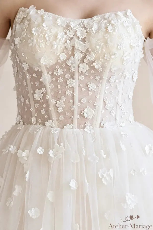 Vue rapprochée du bustier cœur et des mains jointes, dentelle fine avec fleurs 3D