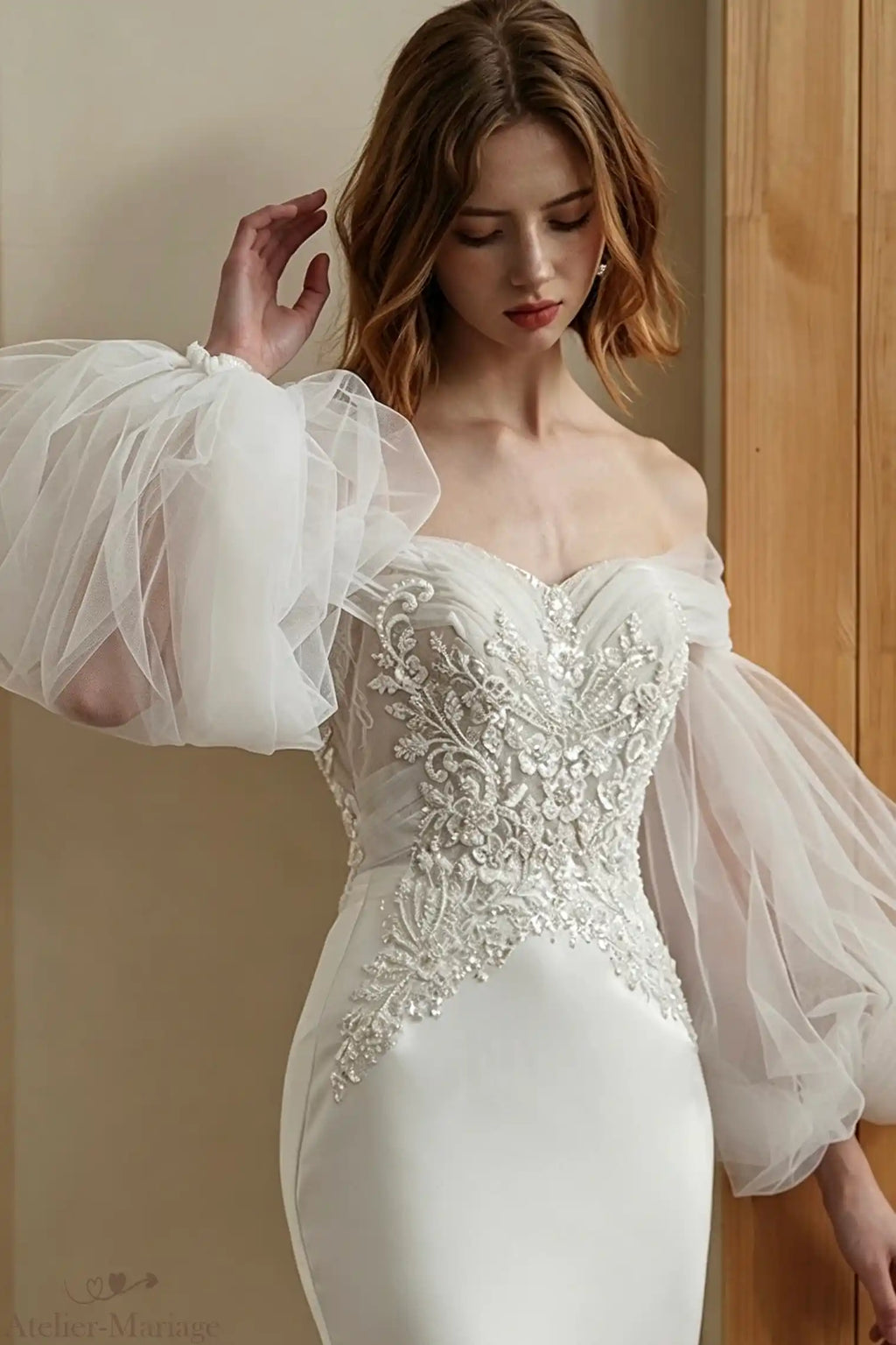 Robe de mariée sirène ornée de perles, portée avec des manches lanternes amovibles en tulle.