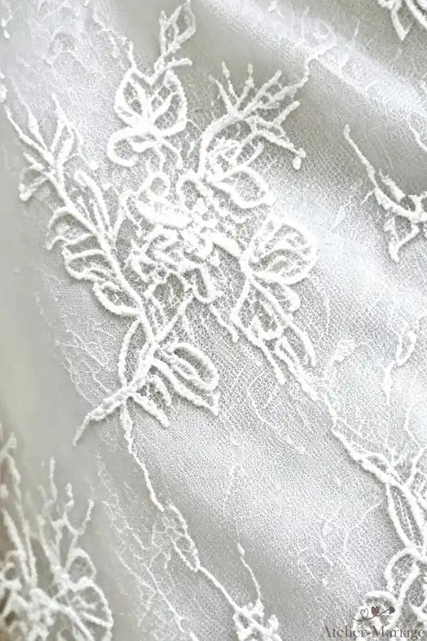 Gros plan sur la dentelle délicate de la robe de mariée bohème