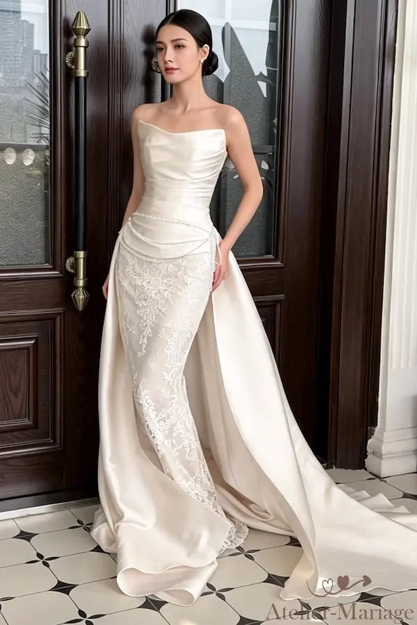 Mariée en robe sirène bohème devant une porte en bois