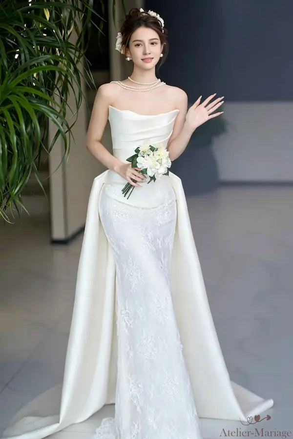 Modèle en robe de mariée sirène bohème faisant un signe de la main