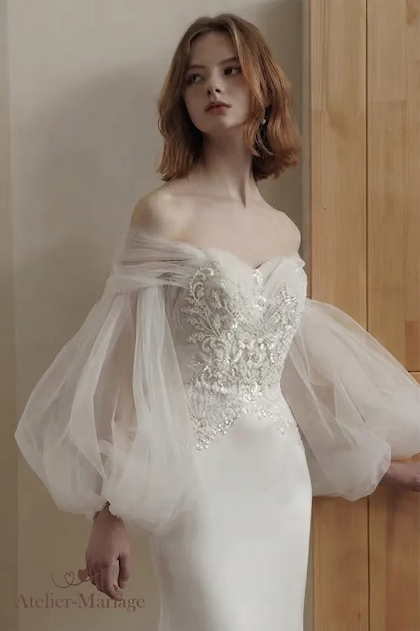 Confection sur-mesure d'une robe sirène avec des détails de perlage et manches amovibles.