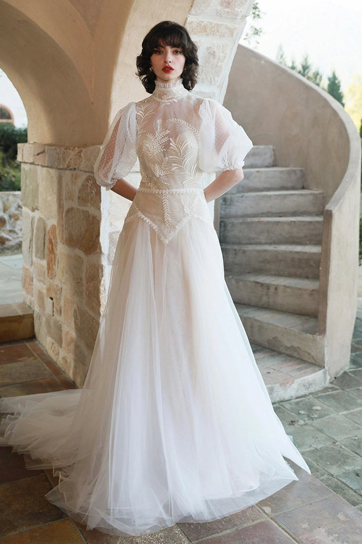 Robe de mariée vintage style victorien avec col montant en dentelle et manches bouffantes en tulle plumetis.