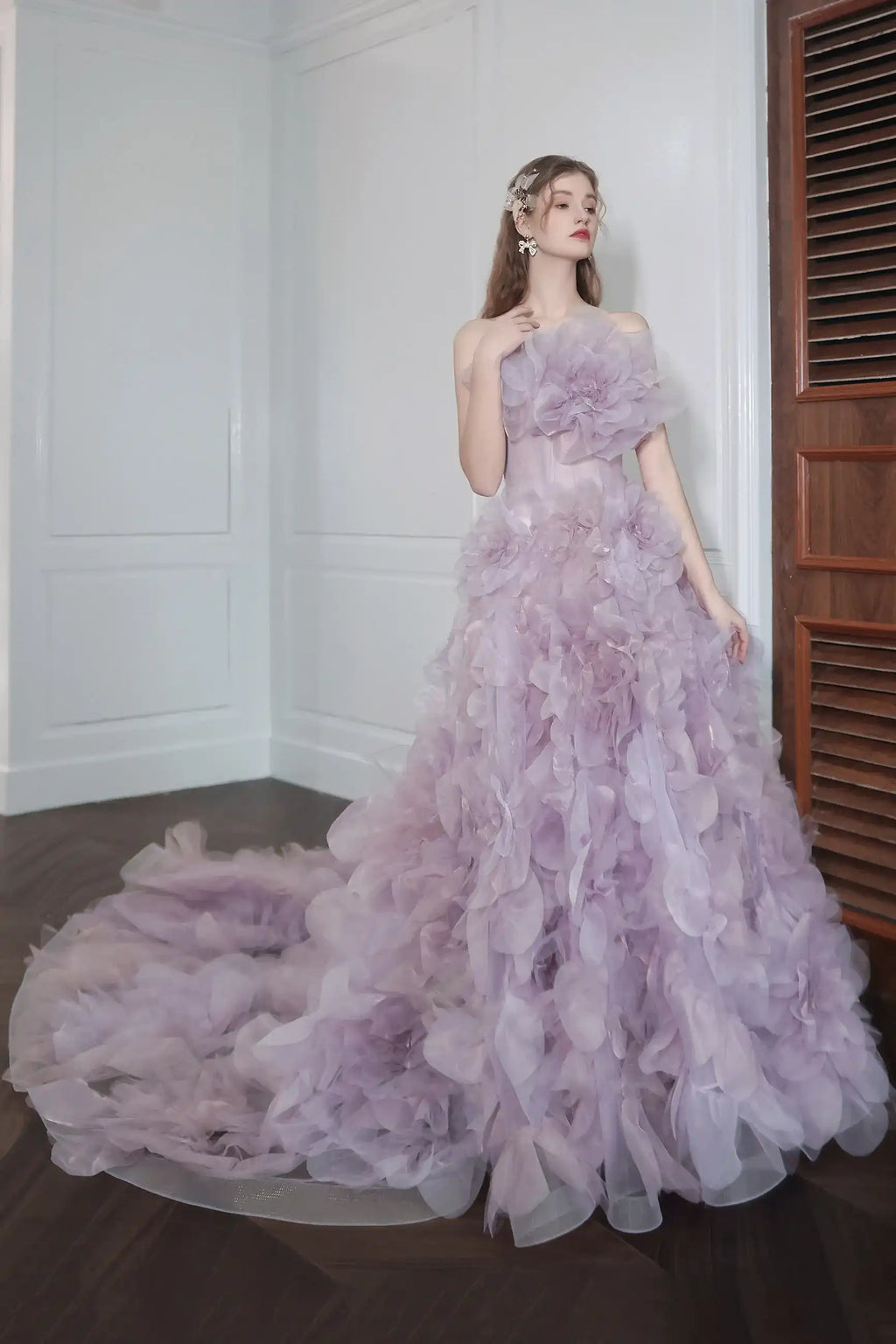Robe de mariée de couleur violet pastel fluide et volumineuse avec des applications florales romantiques.