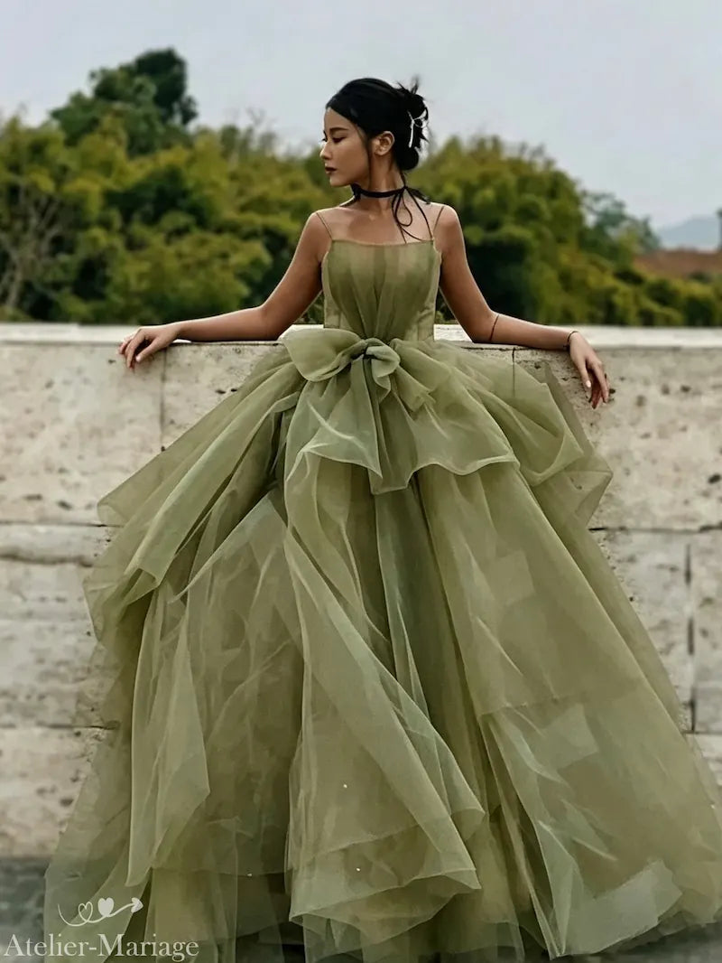 Mariée à la peau métisse et bronzée portant une robe de mariée vert sauge sensuelle