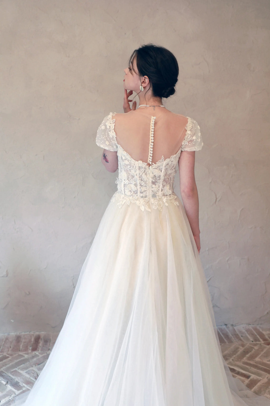 Robe de mariée vintage avec zoom sur les motifs floraux 3D sculptés en relief et cousus main.