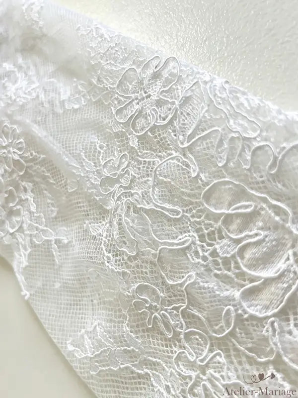 Savoir-faire traditionnel : chaque fleur de dentelle est positionnée à la main par nos artisans.