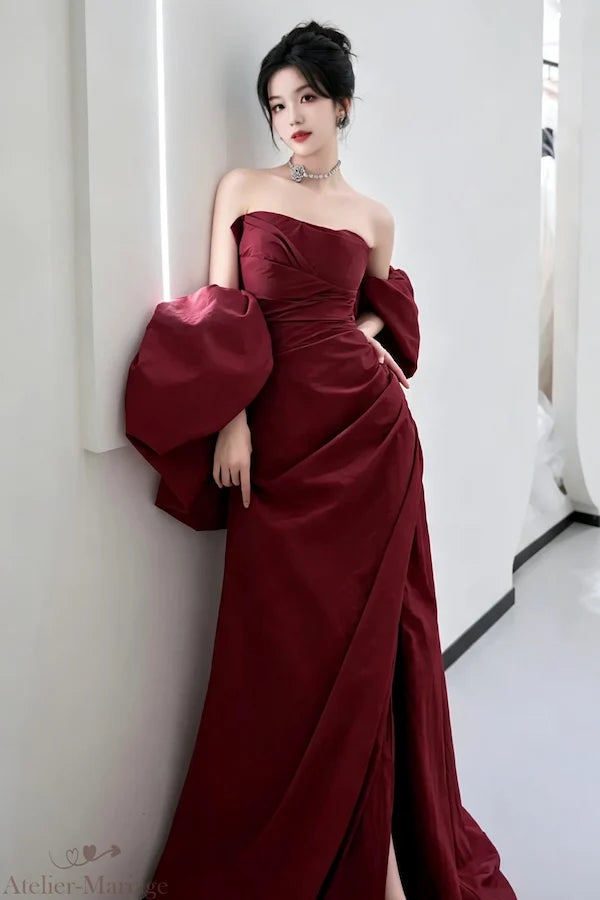 Silhouette fourreau en taffetas rouge bordeaux avec fente haute pour un look de soirée glamour.