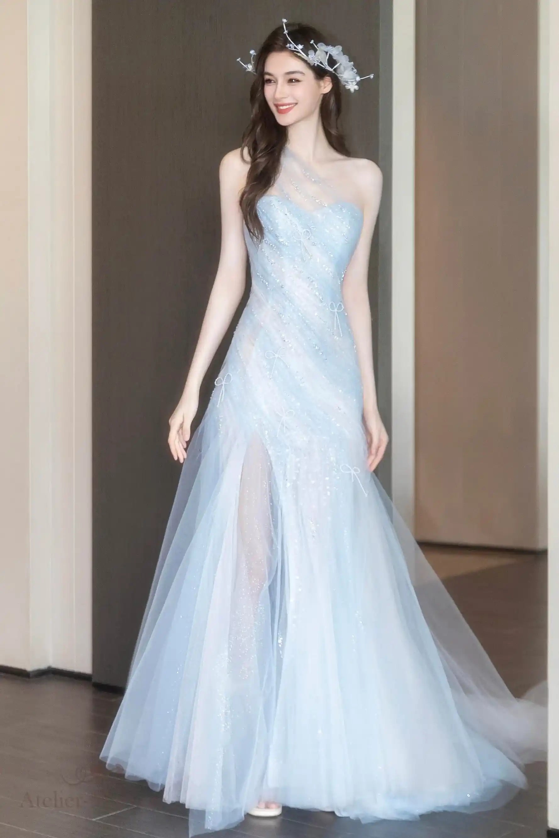 Silhouette fluide d'une robe de mariée bleu nuage avec un jeu de transparence poétique.