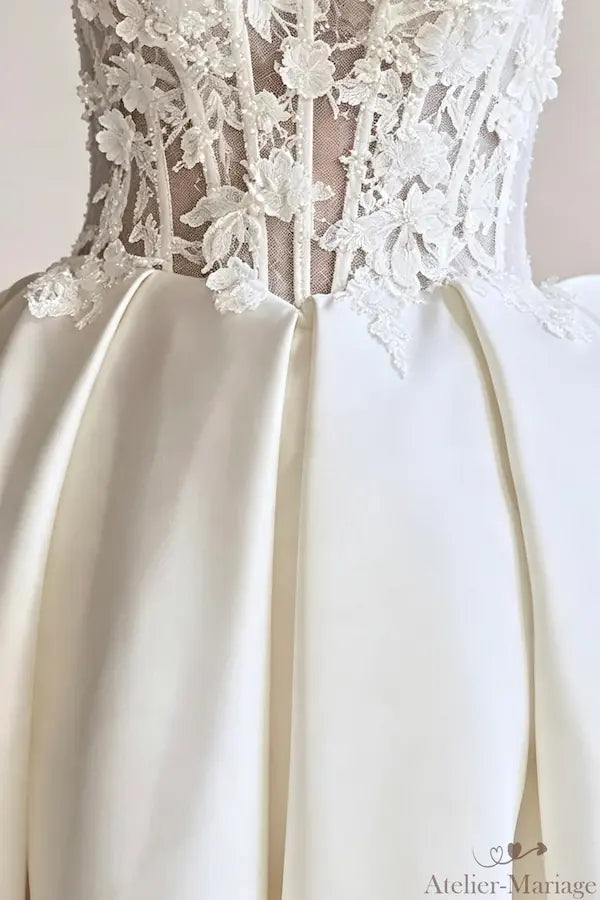 Jonction parfaite entre le bustier fleuri et la jupe volumineuse en satin blanc.