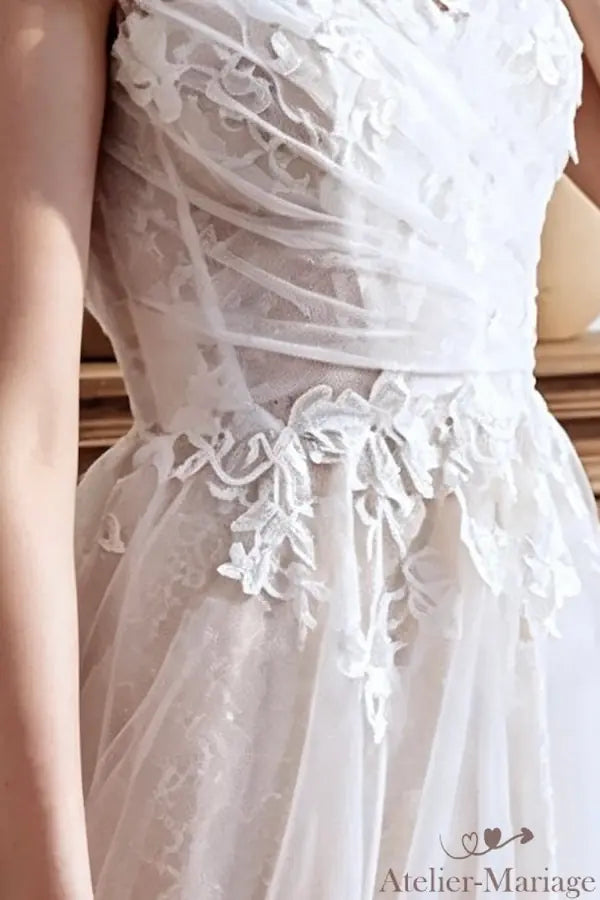 Détail du passage des fleurs 3D du bustier vers la jupe en tulle fluide.