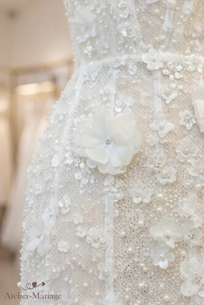 Détail de la taille marquée et d'une grande fleur 3D à cœur de perle sur la jupe