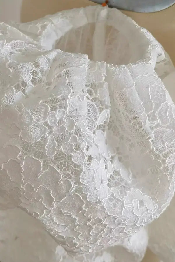 Texture en gros plan de la dentelle florale — motifs floraux et finition festonnée des manches de mariée