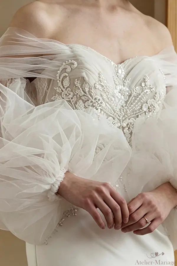 Détail de la texture riche d'une dentelle perlée main, reflet de l'artisanat d'excellence de l'atelier.