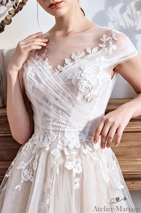 Macro sur le tulle pailleté et les appliques de fleurs blanches artisanales.