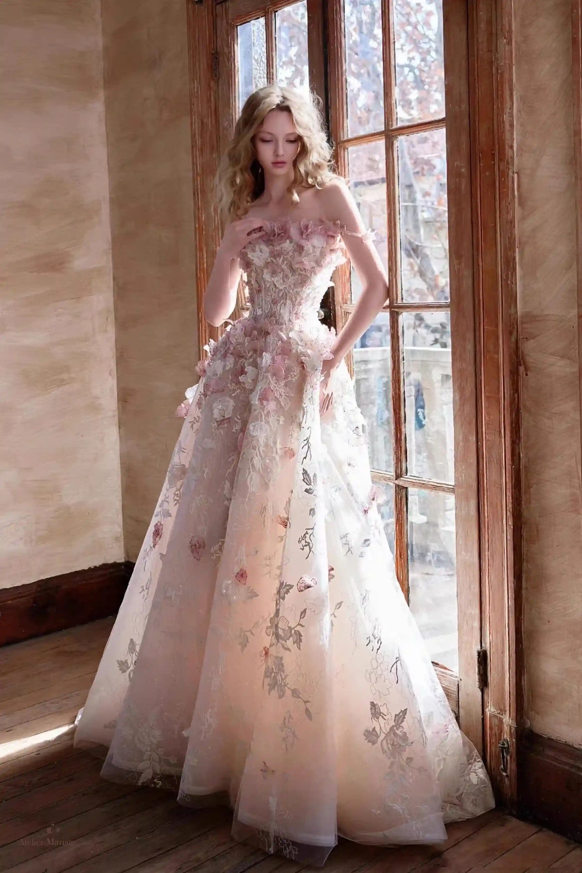 Mariée descendant des escaliers, mettant en valeur la délicate traîne de 30 cm de sa robe en tulle.