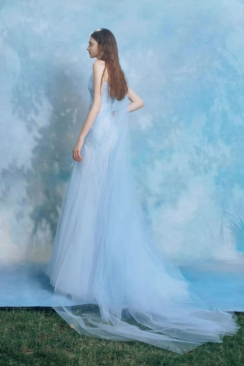 Mariée de profil montrant la délicate traîne de 30 cm de sa robe bleu brume.