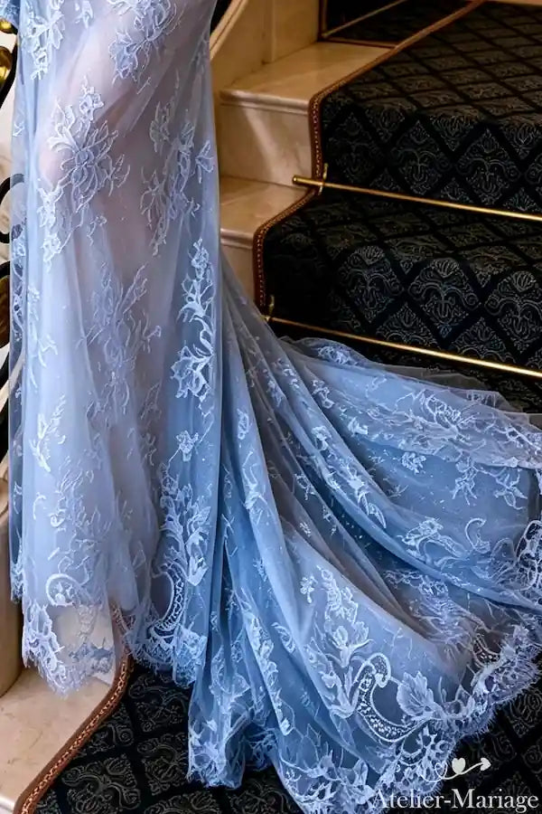 Finition de la traîne avec appliques de dentelle brodées main, savoir-faire traditionnel.