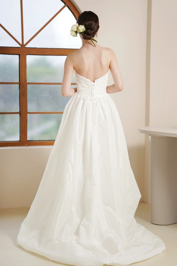 La magnifique traîne fluide à l'arrière de la robe asymétrique en satin.